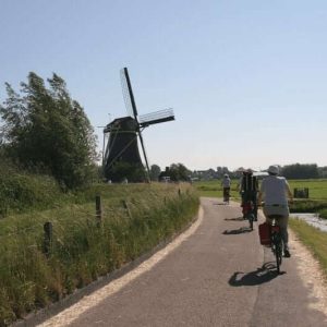 Radfahrer fahren an Windmühlen vorbei